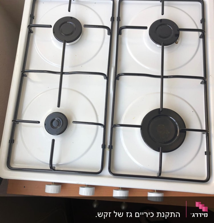 כיריים גז לבנים עם ארבעה מבערים וכפתורי שליטה